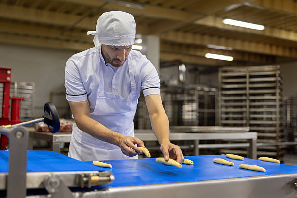 istock Baker making pastries at an industrial bakery 2251231648