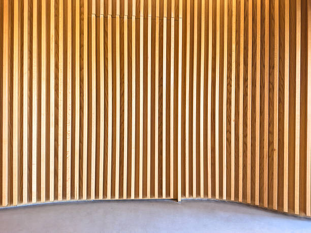 Close up view of a wooden slat panel wall in a modern office interior, showing natural wood texture and vertical lines. Suitable for themes related to architecture, interior design, office decor, backgrounds, textures, and contemporary workspaces.