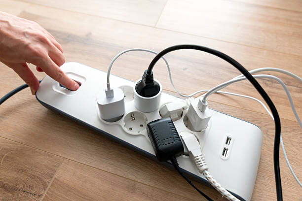 istock Person is plugging in a device to a power strip 2251232416