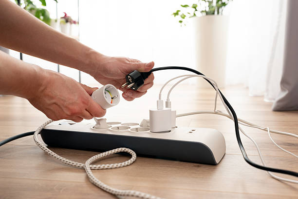 istock Person is plugging in a device to a power strip 2251232434