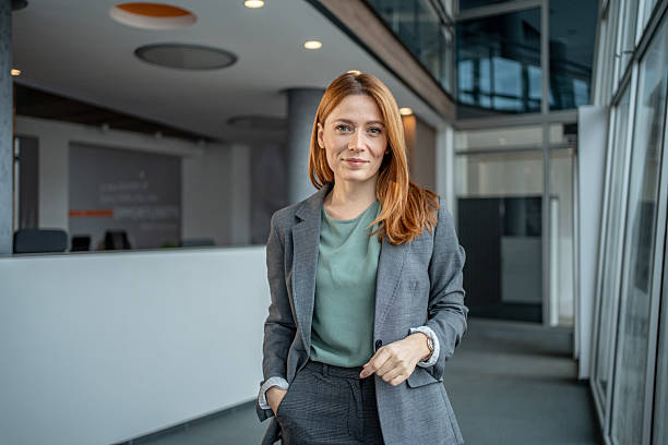 istock Businesswoman standing in modern office building with confident expression 2251233885