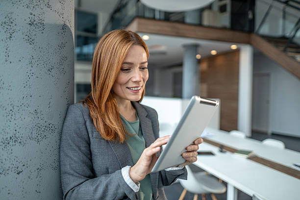 istock Businesswoman using digital tablet confidently in modern office 2251235617