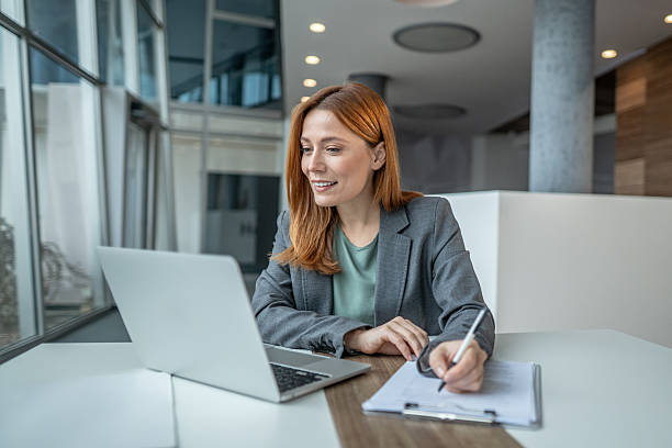 istock Businesswoman collaborating online and taking notes in office 2251236037