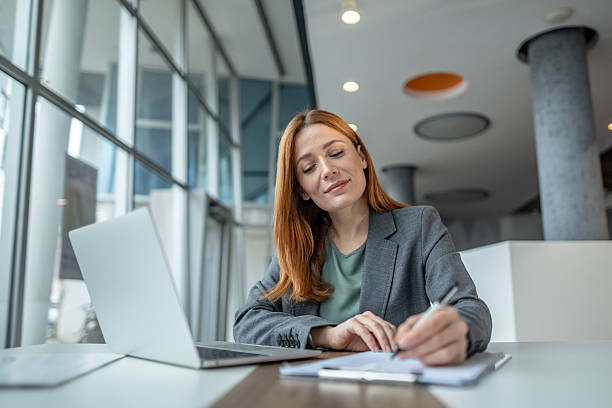 istock Businesswoman writing notes working at modern office 2251236054