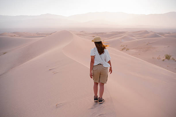 istock Young woman walking in the desert at sunset. 2251238921