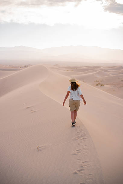 istock Woman walking in the desert. 2251238957