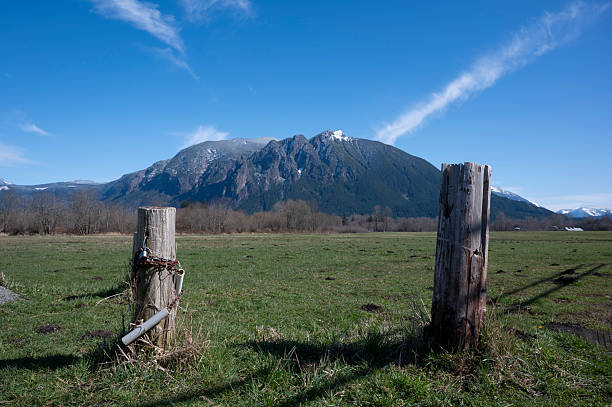 Wooden fence overlooks a scenic view of rolling hills. Under view of bright blue sky with fluffy white clouds. Traveling in Thailand of village Ban Jabo Mae Hong Son.