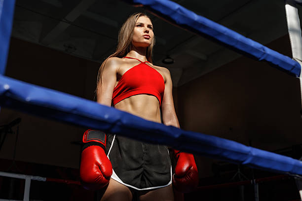 istock Female boxer standing in ring with red gloves ready for fight 2251242177
