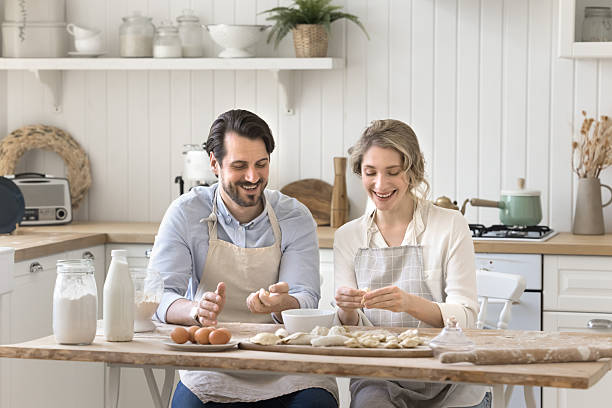 istock Happy spouses shape pies from dough together in joyful mood 2251242289