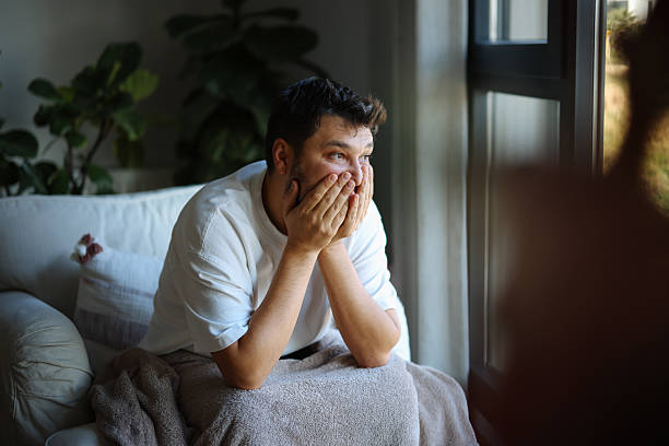 istock Man sitting on sofa with head in hands 2251242728