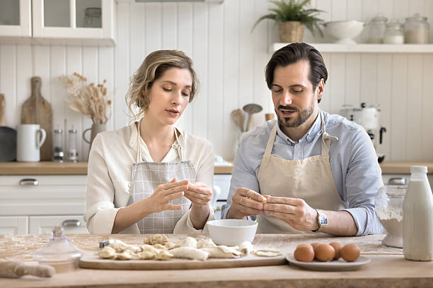 istock Portrait happy married couple sitting at kitchen table forming dumplings 2251243142