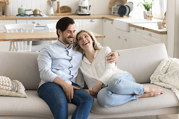 istock Happy loving married couple relax on comfy sofa hug talk 2251243332