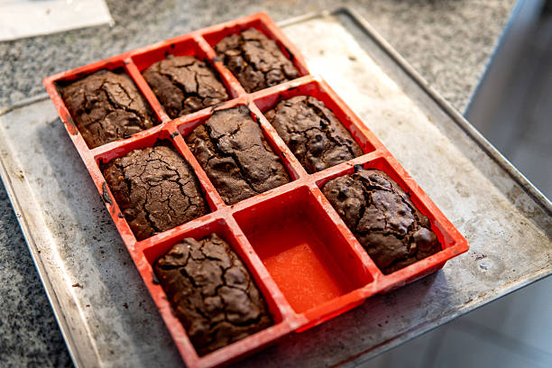 Brownies baking in a red silicone mold on a metal oven tray