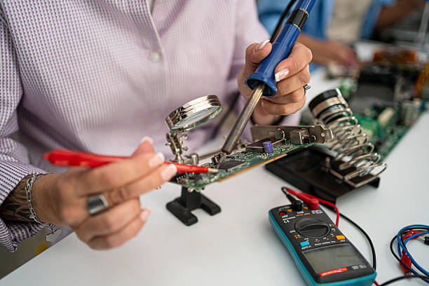 istock Woman repairing circuit board using soldering iron 2251247552