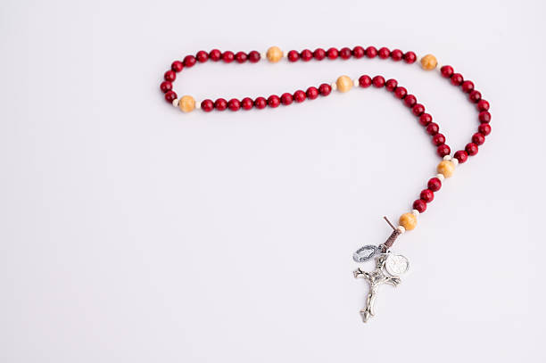 istock Red and yellow bead rosary with crucifix on a plain background 2251248393