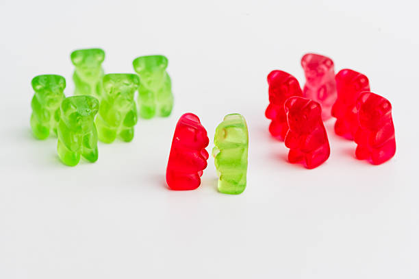 Gummy bears in green and red arranged on a white surface