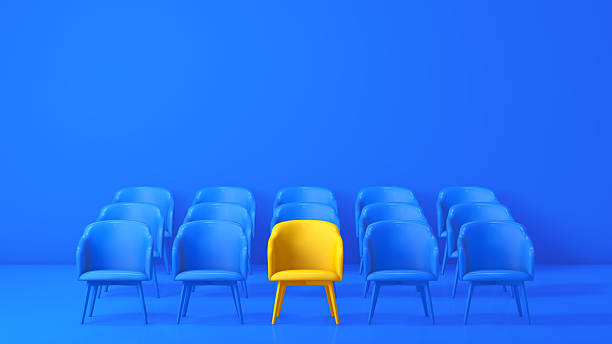 istock 3D Yellow Chair Standing Out Among Blue Chairs – Uniqueness & Leadership Concept 2251250174