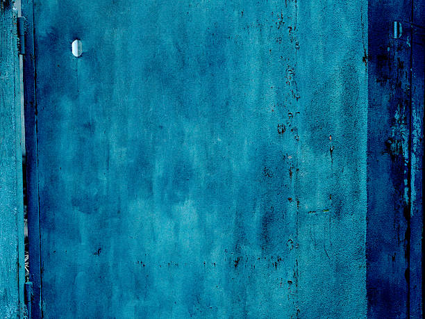 A moody, abstract blue grunge wall background with distressed texture and dark contrast. This versatile backdrop offers ample copy space for graphic design, web banners, or artistic presentations. Deep sea or ocean water abstract and deep theme.