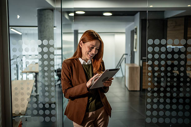 istock Businesswoman standing in modern office using digital tablet 2251255343