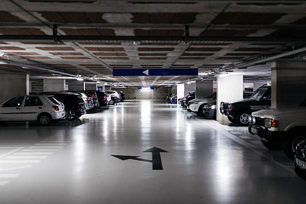 istock Dimly lit underground parking garage with various parked vehicles 2251256501