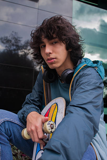 Confident young man with headphones and a skateboard
