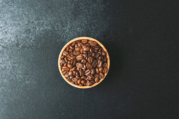 istock Coffee beans in wooden bowl on dark background 2251263286
