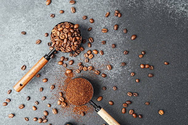 istock Ground coffee and beans in measuring scoops on dark background 2251263303