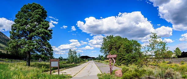 This section of the original Route 66 roadbed in East Flagstaff, Arizona, has been converted into an urban trail and is part of the Flagstaff Urban Trails System (FUTS). This short trail segment follows a portion of the historic road alignment and honors what was once part of the iconic “Main Street of America.”  Route 66 played a crucial role in the development and culture of the American West during the 20th century.  The urban trail is designed to accommodate a variety of users, including walkers, runners, cyclists, and skaters.  The trail provides scenic views of the surrounding landscape, including the ponderosa pine forests and volcanic mountains that characterize the Flagstaff area. This makes it not only a historical route but also a pleasant and picturesque place for outdoor activities.  Overall, the conversion of this section of the original Route 66 roadbed into an urban trail in East Flagstaff serves as a meaningful blend of historical preservation and modern recreational development.  The historical allure of Route 66 attracts tourists, boosting local tourism and contributing to the economy.
