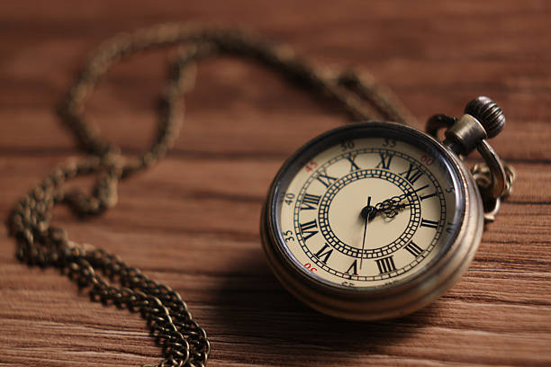 istock Pocket clock with chain on wooden table, closeup 2251269324
