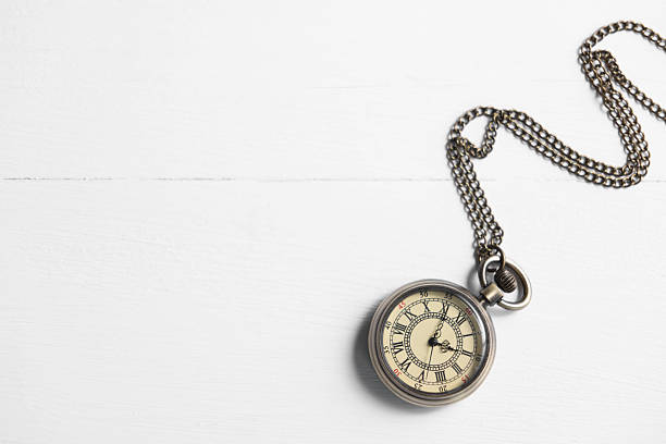 Pocket clock with chain on white wooden table, top view. Space for text