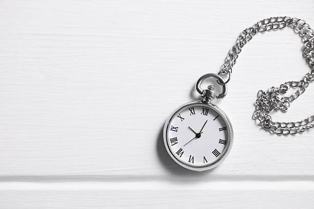 istock Silver pocket clock with chain on white wooden table, top view. Space for text 2251269338