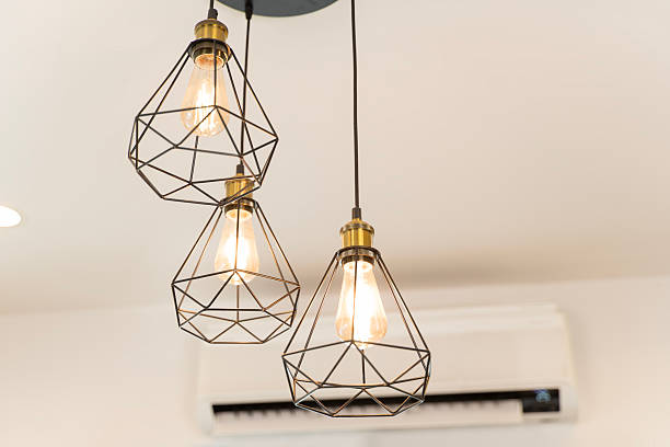 istock Modern pendant lights with wireframe geometric design glowing warm in cozy interior home decoration style 2251270456