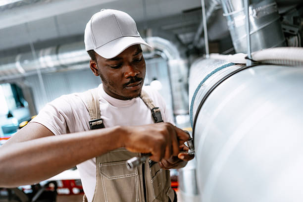 istock Man works on industrial pipe maintenance in a large workshop during the day 2251271420
