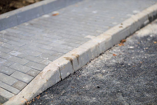 istock Freshly paved asphalt road with stone curb and concrete sidewalk 2251273809