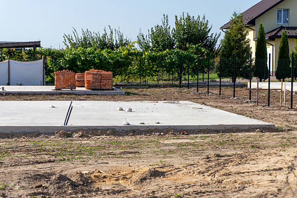 istock Construction site shows a concrete slab and building materials on a sunny day in a rural area with trees in the background 2251274023