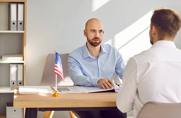 istock USA consul talking to young man about his problems with immigration and visa application 2251277341