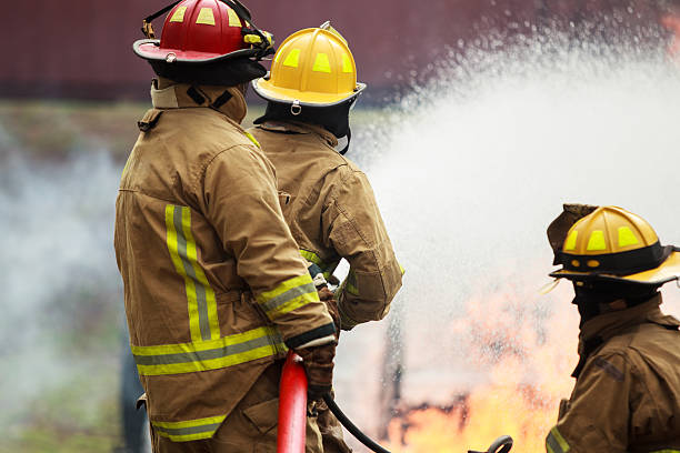 istock Firefighters spraying water to control extinguish an intense blaze. 2251279962