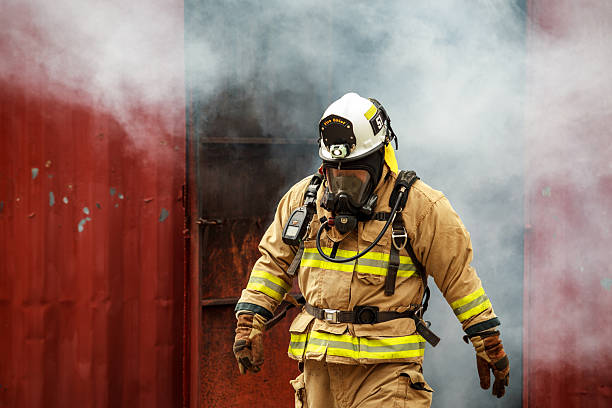 istock Firefighter in full gear emerging from a smoke filled or burning structure. 2251279964
