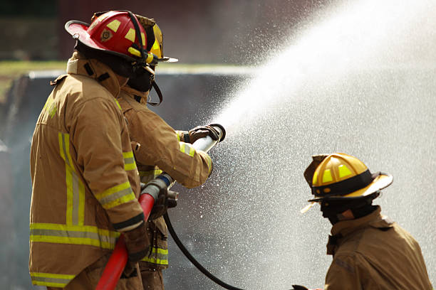 istock Firefighters spraying water to control extinguish an intense blaze. 2251279966