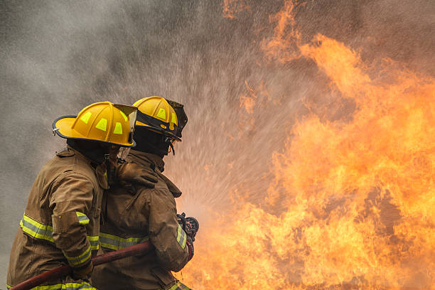 istock Fire fighter spraying water to control intense flames during fire training. 2251279987
