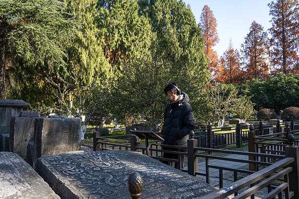 asian boy reads display by ancient stones