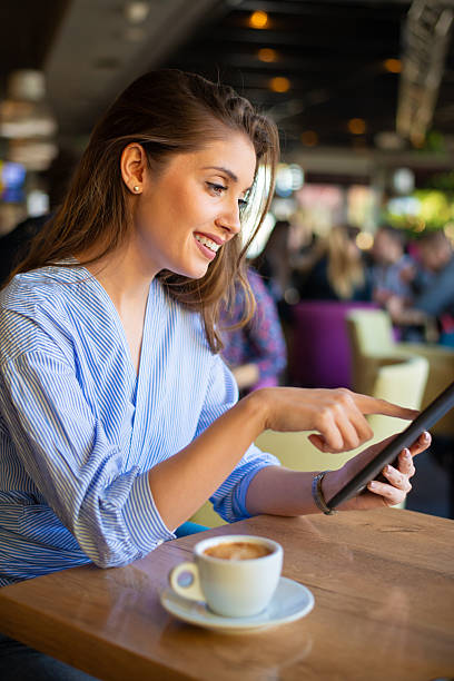 istock Young smiling woman drinking coffee in the cafeteria 2251281045