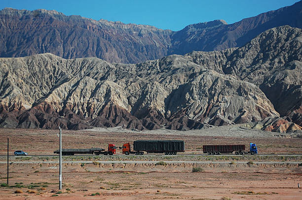 istock Trucks on a road with colorful mountain range in the background 2251282122