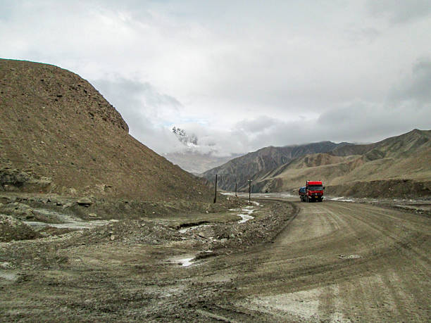 istock A truck driving on a rough mountain road under cloudy sky 2251282164