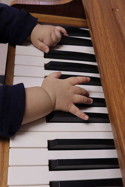 istock Baby’s First Touch on Musical Instrument 2251282719