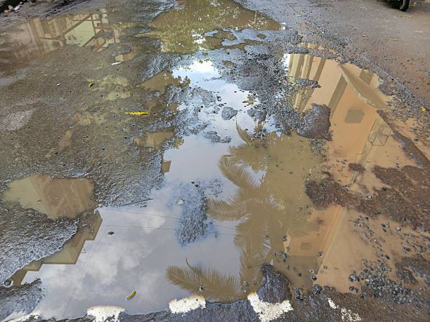 istock Large potholes, damaged road infrastructure after rain 2251282764