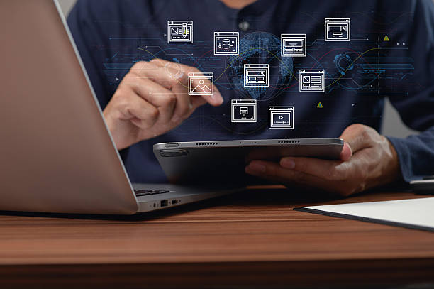 istock Person Interacting with Tablet and Laptop in a Modern Digital Workspace 2251286040