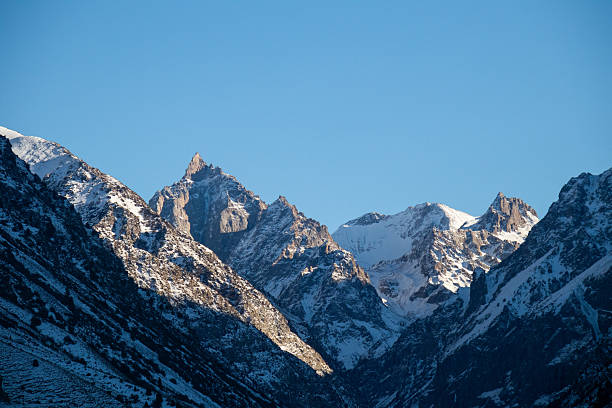 istock Jagged, snow-capped mountain peaks dramatically lit by the sun 2251290155
