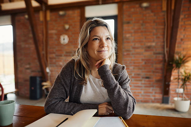 istock Smiling creative woman day dreaming at home office. 2251301818