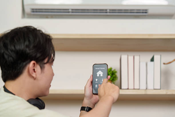 istock Smart Home. Young man controlling devices with smartphone. 2251302999